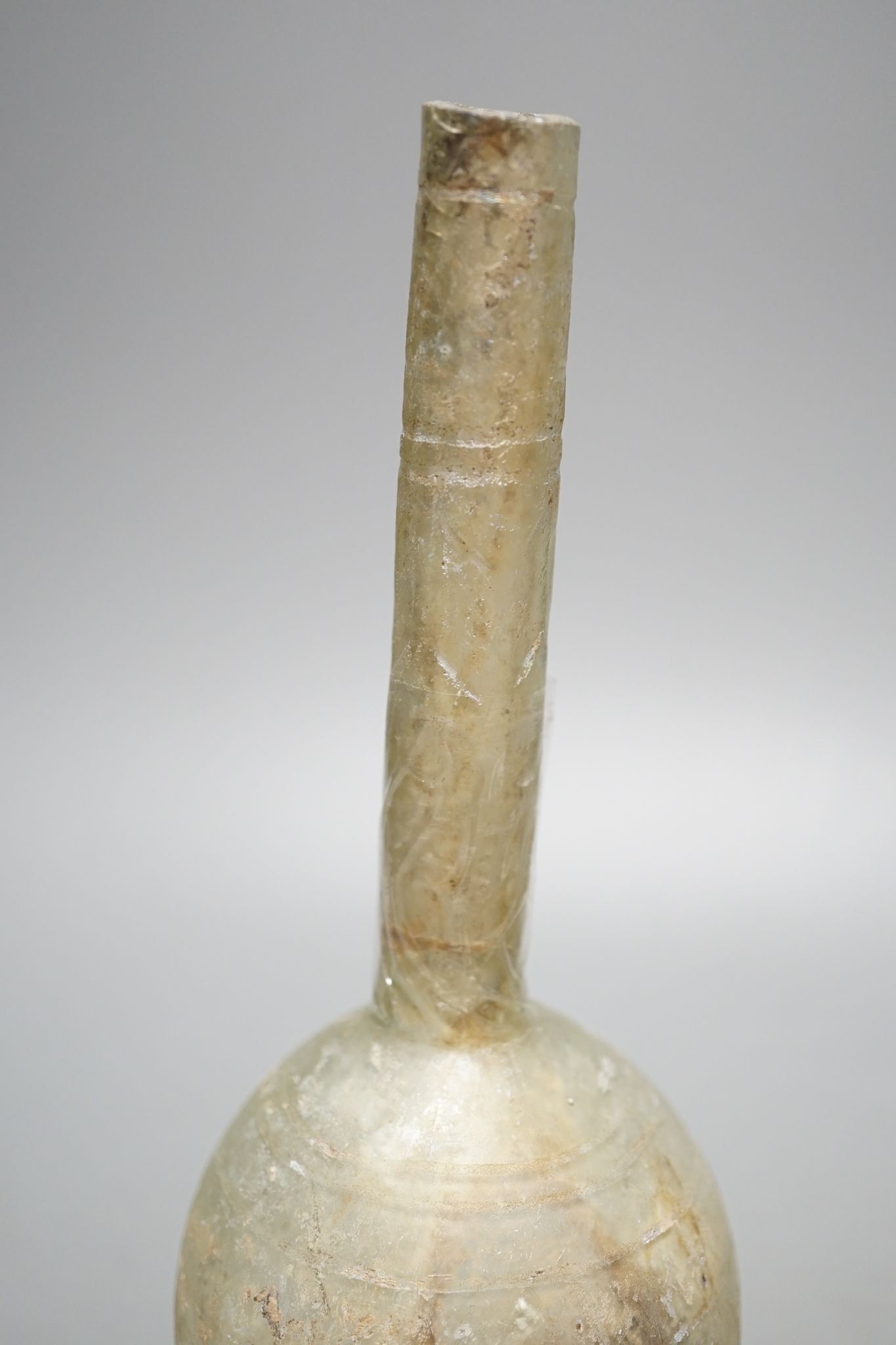 A Kashan oil lamp, 13th/14th century, and an early Islamic glass bottle., Bottle 22 cms high.